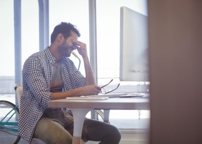 Depressed businessman sitting at desk in office